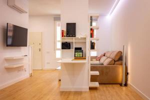 een woonkamer met een bank en een bureau bij Elegante y nuevo apartamento junto al Palacio Congresos in Sevilla