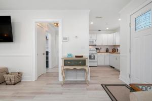 une cuisine avec des armoires blanches et une table à l'intérieur dans l'établissement Coastal Vibes! Tropical heated pool home short drive to the beach, à Bradenton