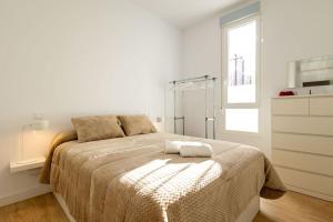 ein Schlafzimmer mit einem Bett mit zwei Handtüchern darauf in der Unterkunft Elegante y nuevo apartamento junto al Palacio Congresos in Sevilla