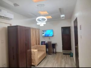 a living room with a couch and a flat screen tv at HOTEL D RITZ in Aba Adi