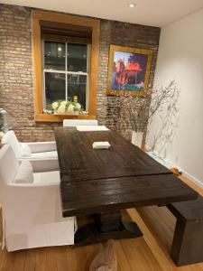 salon z drewnianym stołem i kanapą w obiekcie Tribecca Modern Brick Wall 3BR 2BA w Nowym Jorku
