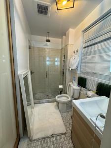 a bathroom with a shower and a toilet and a sink at Tribecca Modern Brick Wall 3BR 2BA in New York