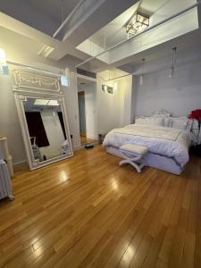 1 dormitorio con 1 cama grande y espejo grande en Tribecca Modern Brick Wall 3BR 2BA en Nueva York