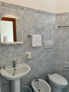 bagno con lavandino, servizi igienici e specchio di Hotel Blue Ribbon a Rimini