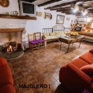salon z kanapą i kominkiem w obiekcie Cortijo Rural Majolero w mieście Castillo de Locubín