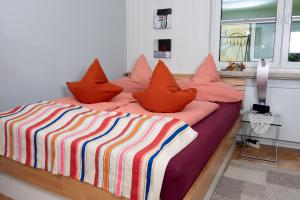 a bedroom with a bed with orange pillows on it at Birgits Lodge in Rheinbach