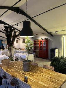 PİA MARE OTEL في Gündüzlü: مطعم مع طاولة خشبية مع كراسي وضوء مستنقع