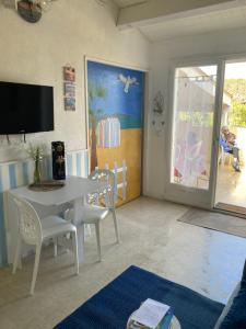 Televízia a/alebo spoločenská miestnosť v ubytovaní maison climatisée à 500m de la plage dans résidence