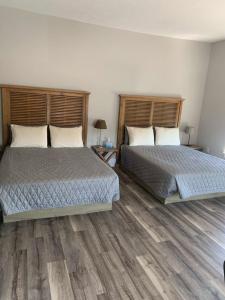 two beds in a bedroom with wooden floors at Boutique Hotel Room 8 in Northport