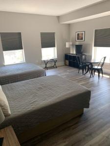 a hotel room with two beds and a table and chairs at Boutique Hotel Room 8 in Northport