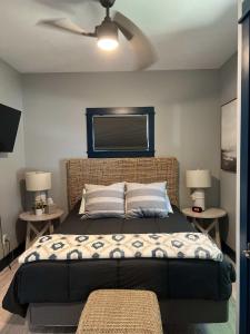 a bedroom with a large bed with a ceiling fan at Modern Cottage in the Heart of Charlevoix in Charlevoix