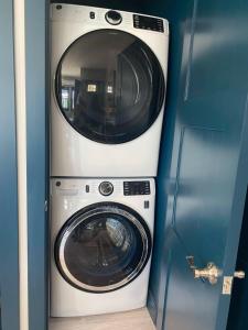 a washer and a washing machine in a room at Modern Cottage in the Heart of Charlevoix in Charlevoix