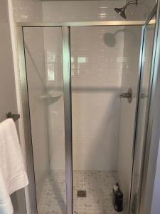 a shower with a glass door in a bathroom at Modern Cottage in the Heart of Charlevoix in Charlevoix