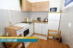 una pequeña cocina con nevera blanca y mesa en Little Portland Apt en Budapest