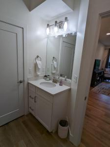 a white bathroom with a sink and a mirror at Capri Condo in Downtown Traverse City in Traverse City +47 photos