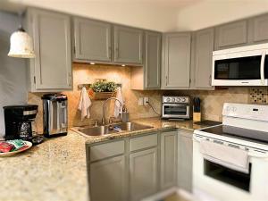 a kitchen with white cabinets and a sink at 6 D, One Bedroom Condo in Destin