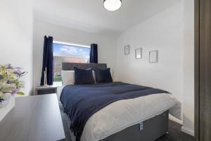 1 dormitorio con cama, mesa y ventana en Stylish home Near Durham Heritage Coast Sleeps 5 en Durham