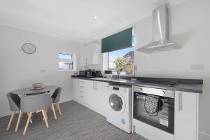a kitchen with a washing machine and a table at Stylish home Near Durham Heritage Coast Sleeps 5 in Durham