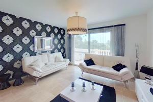 una sala de estar con 2 sofás blancos y una mesa. en CASA-Louis modern & chic villa Cannet-les-Maures, en Le Cannet-des-Maures