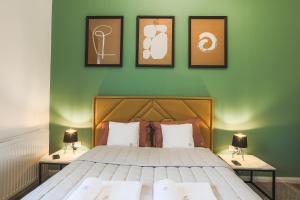 a bedroom with a bed with three pictures on the wall at VILLA TOURI - Touri Alpesi Birtok in Bozsok