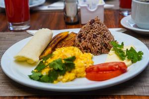 a white plate of breakfast food on a table at La Fortuna Lodge by Treebu Hotels in Fortuna