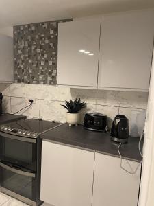 a kitchen with white cabinets and a stove top oven at Inviting 1-Bed Apartment in London in London