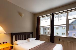 1 dormitorio con cama y ventana grande en YWCA Banff Hotel, en Banff