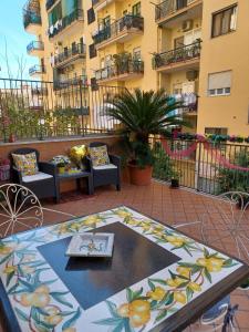 eine Terrasse mit Tisch und Stühlen und ein Gebäude in der Unterkunft La Terrazza di Monica & Teresa in Portici