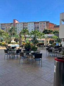 an outdoor patio with tables and chairs and tables and umbrellas at Flat Vereda, 524 -Rio quente. in Rio Quente