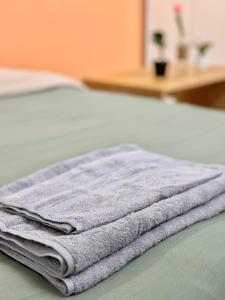 una pila de toallas sentadas encima de una cama en Sweet home * Center * Cozy, en Hanói