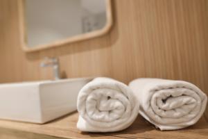 um monte de toalhas sentadas num balcão ao lado de um lavatório em Le Petit Apartamentos em Santander