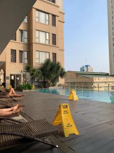 a swimming pool with yellow barriers in front of a building at Golden Apartment in Ho Chi Minh City