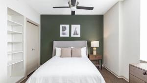1 dormitorio con cama blanca y pared verde en Landing - Modern Apartment with Amazing Amenities (ID9312X01) en Detroit