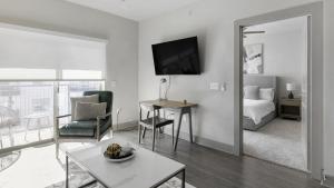 uma sala de estar branca com uma cama e uma mesa em Landing - Modern Apartment with Amazing Amenities (ID9504X23) em Plano