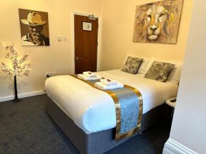 una habitación de hotel con 2 camas y una pintura del león en la pared en United Lodge Hotel, en Londres