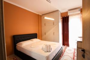 Un dormitorio con una cama con toallas. en Vasho Luxury Apartment, en Gjirokastra