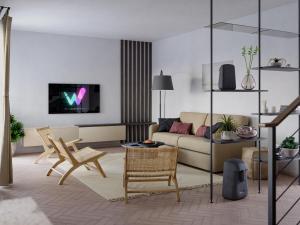 a living room with a couch and a tv on a wall at Wild Adriatic Way in Zagorje