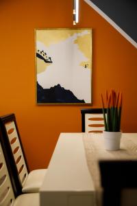comedor con paredes de color naranja, mesa y sillas en Vasho Luxury Apartment, en Gjirokastra