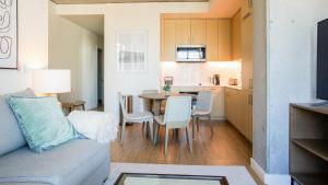 奧克蘭的住宿－Landing Modern Apartment with Amazing Amenities (ID2480X10)，客厅以及带沙发和桌子的厨房。