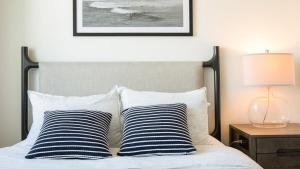 uma cama com duas almofadas azuis e brancas e um candeeiro em Landing Modern Apartment with Amazing Amenities (ID2480X10) em Oakland