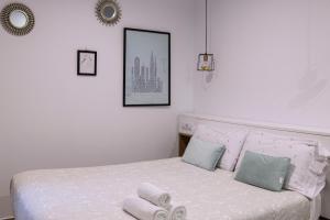 Un dormitorio con una cama blanca con toallas. en BELIA A.T., en Cáceres
