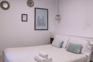 a bedroom with a white bed with towels on it at BELIA A.T. in Cáceres