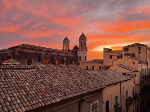 a view of the roofs of a city at sunset at Casa Flos31 in Catania