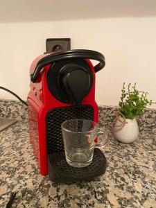 een rood koffiezetapparaat met een glas op een aanrecht bij Cosy & magnifique appartement Marrakech in Marrakesh