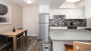 a kitchen with a refrigerator and a wooden table at Landing Modern Apartment with Amazing Amenities (ID8237X51) in Chino Hills