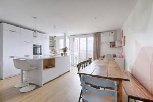 uma cozinha e sala de jantar com uma mesa de madeira em Résidor - Warm and bright 6P apartment! em Paris