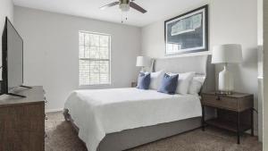1 dormitorio con 1 cama con almohadas azules y TV en Landing Modern Apartment with Amazing Amenities (ID1167X009) en El Paso