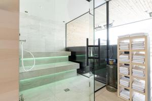 a bathroom with a glass shower and stairs with towels at Hotel Baer & Post Zernez in Zernez