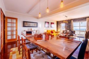 a living room with a large wooden table and chairs at Saudades do Sol y Mar Apartment in Lagoa