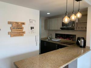 a kitchen with a counter top and some lights at Lujoso, confortable y hermoso Apto en Funza, in Funza